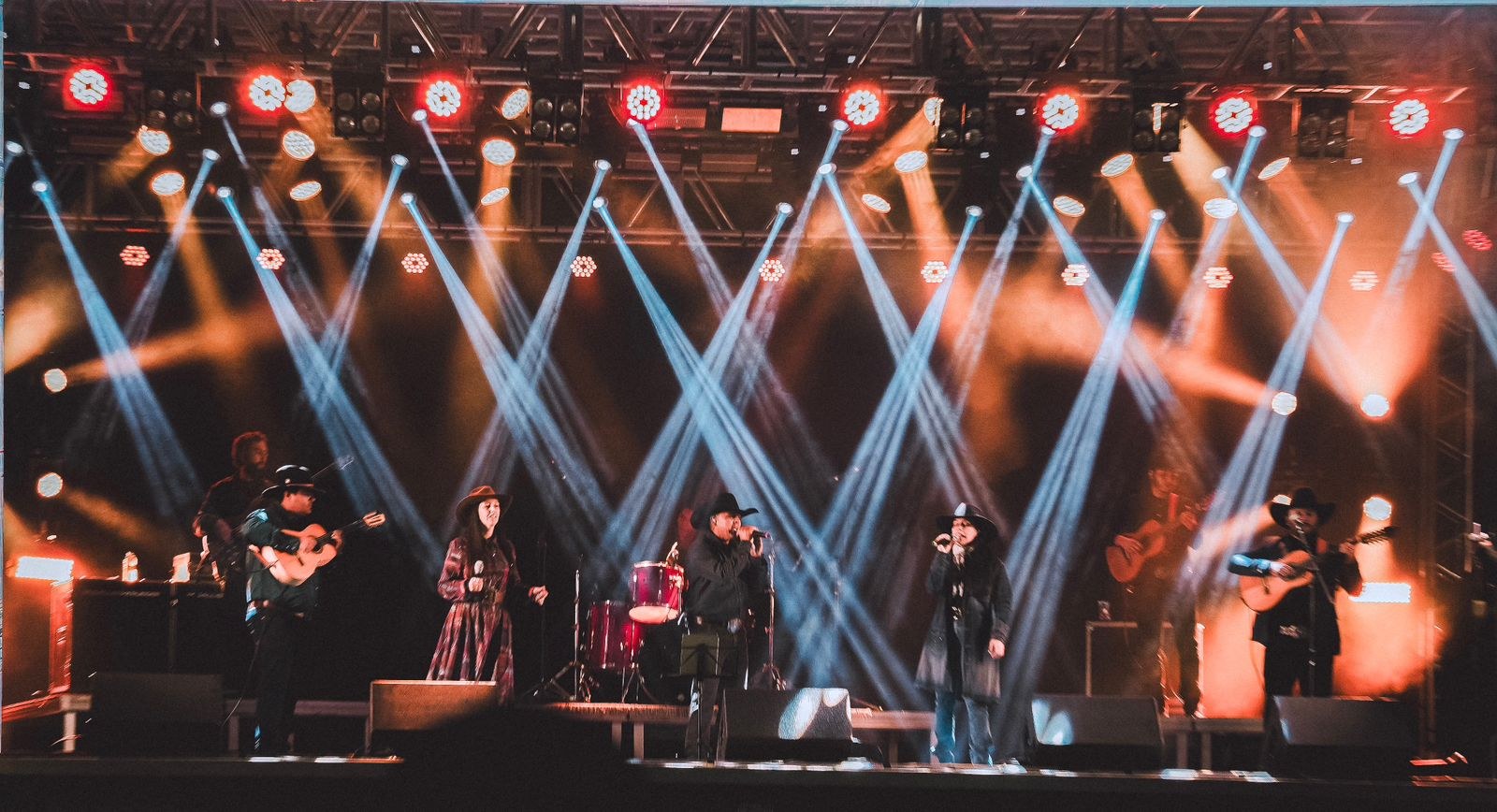 Grupo Violeiros da Terra em um grande palco iluminado